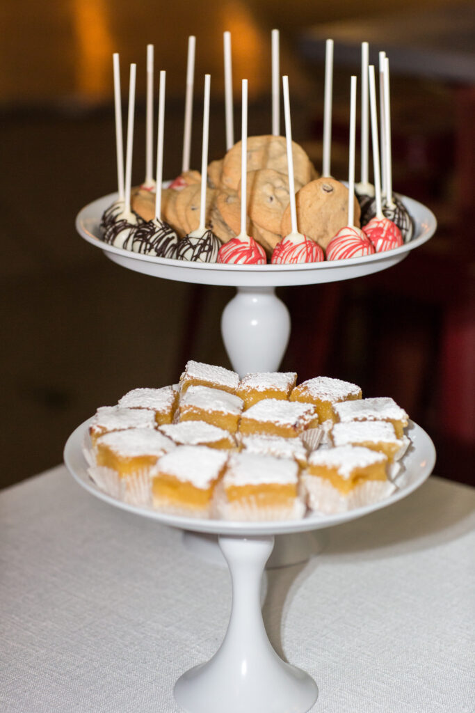Lemon bars and cake pops served on tiered platters as a late night snack for wedding guests