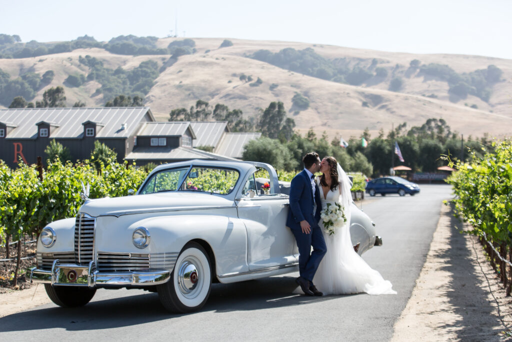 A classic, vintage, luxury car is always a good idea!  Bride and groom dramatic portrait in front of their classic Packard convertible arriving at their wedding reception
