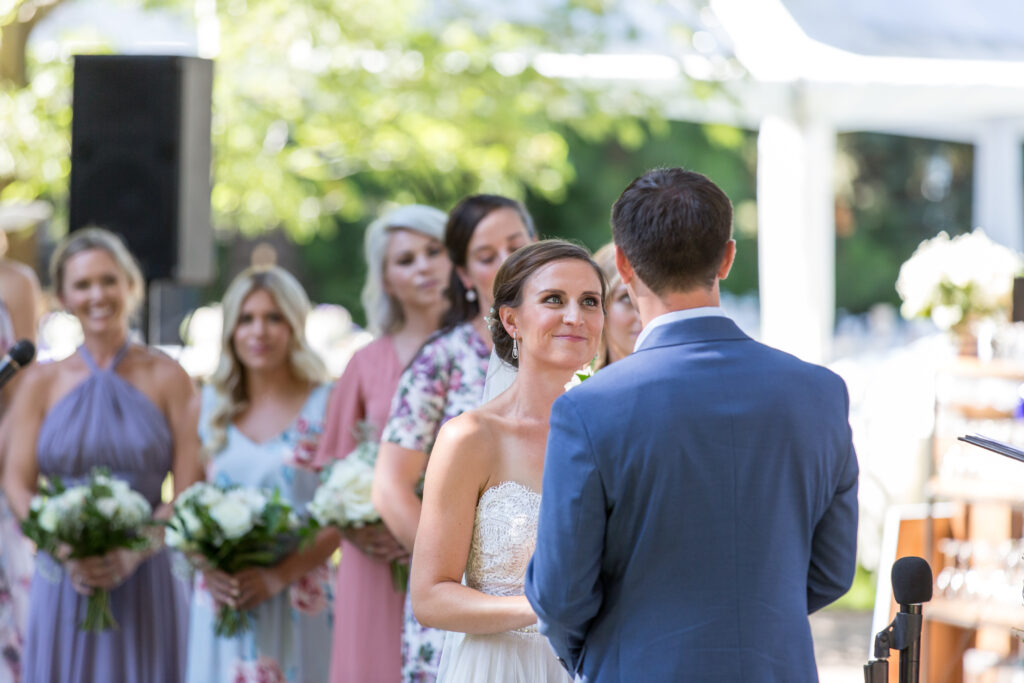 An emotional bride looks at her husband while saying her vows