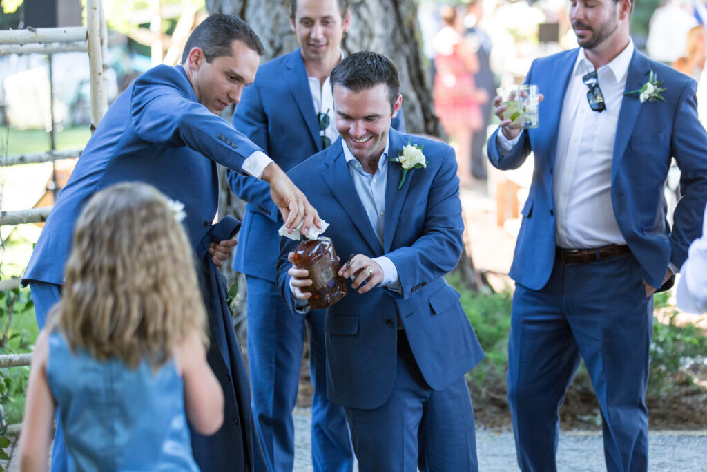 Groom and best man inspect and open the buried bottle of bourbon