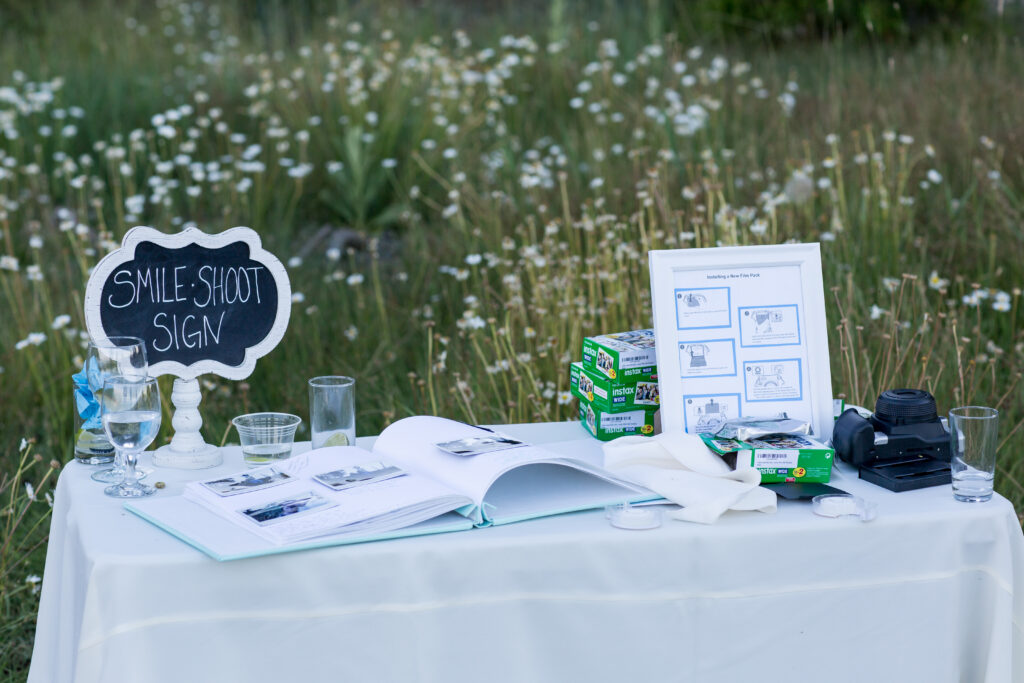 Smile, shoot, sign.  Polaroids and an album encourage guests to take pictures of the wedding fun